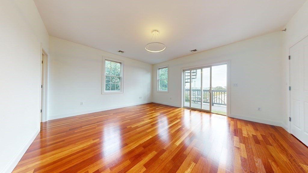 604 Freeport Street, Unit PH 5 Boston, MA 02122 - Photo 28 of 38 a view of an empty room with wooden floor and a window