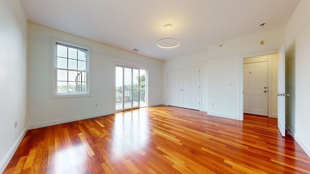 604 Freeport Street, Unit PH 5 Boston, MA 02122 - Photo 29 of 38 a view of an empty room with wooden floor and a window