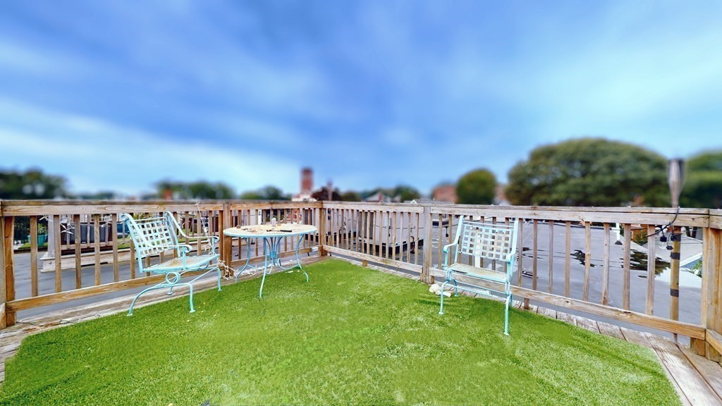 604 Freeport Street, Unit PH 5 Boston, MA 02122 - Photo 35 of 38 a view of a chairs and table on the wooden deck