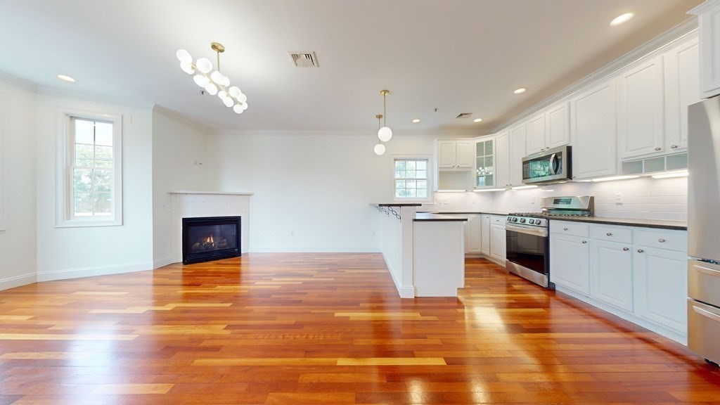 604 Freeport Street, Unit PH 5 Boston, MA 02122 - Photo 4 of 38 a large white kitchen with a stove top oven and kitchen view