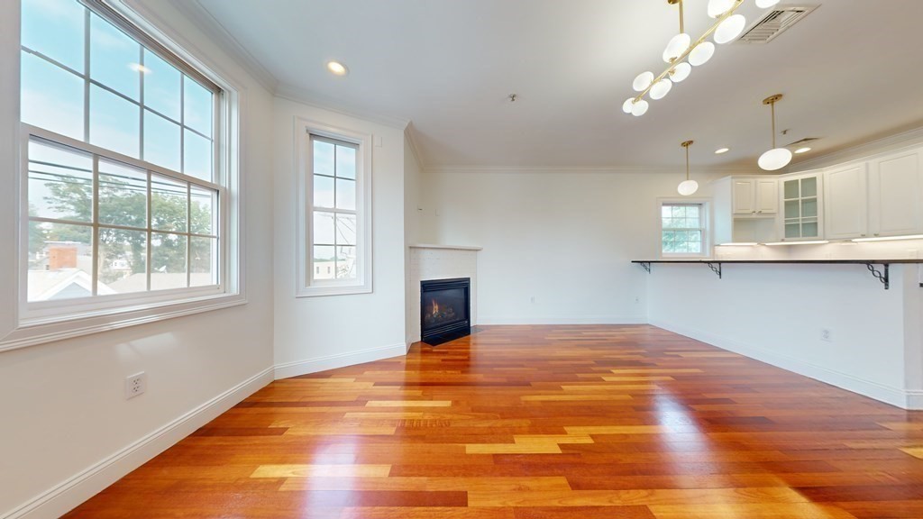 604 Freeport Street, Unit PH 5 Boston, MA 02122 - Photo 5 of 38 a view of a kitchen with wooden floor and a window