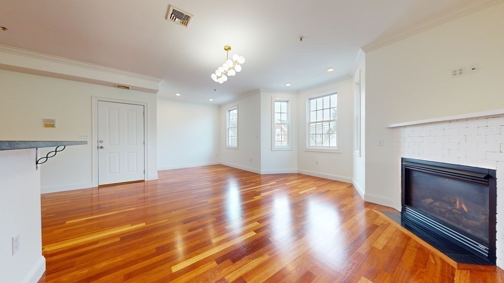 604 Freeport Street, Unit PH 5 Boston, MA 02122 - Photo 7 of 38 a view of empty room with wooden floor and fireplace