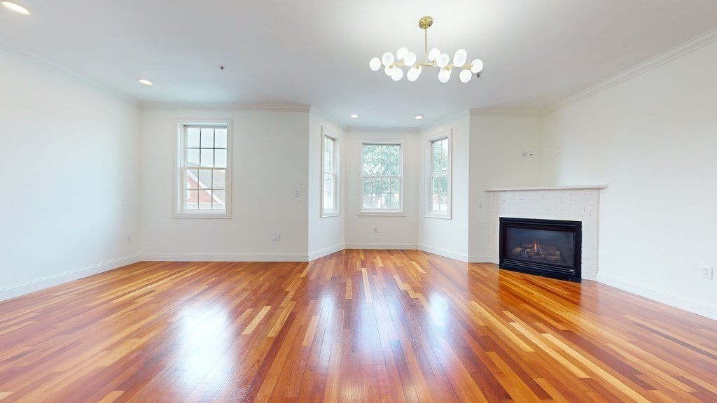 604 Freeport Street, Unit PH 5 Boston, MA 02122 - Photo 9 of 38 wooden floor fireplace and windows in an empty room