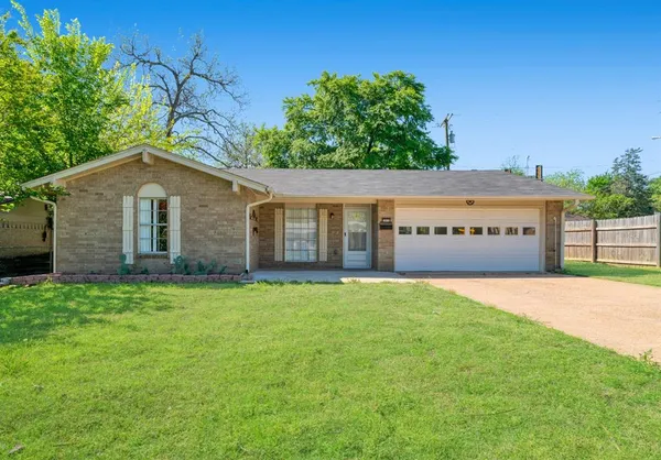 a view of a house with a yard and fence