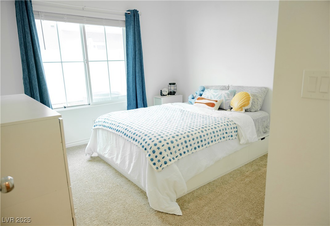 7342 North Decatur Boulevard, Unit 5 North Las Vegas, NV 89084 - Photo 11 of 29 Bedroom with light carpet, multiple windows, and baseboards