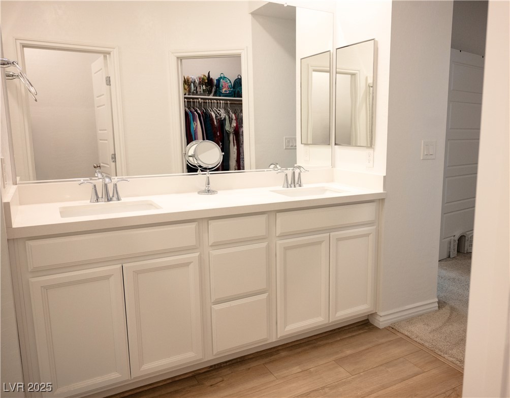 7342 North Decatur Boulevard, Unit 5 North Las Vegas, NV 89084 - Photo 17 of 29 Bathroom featuring double vanity, wood finished floors, and a spacious closet