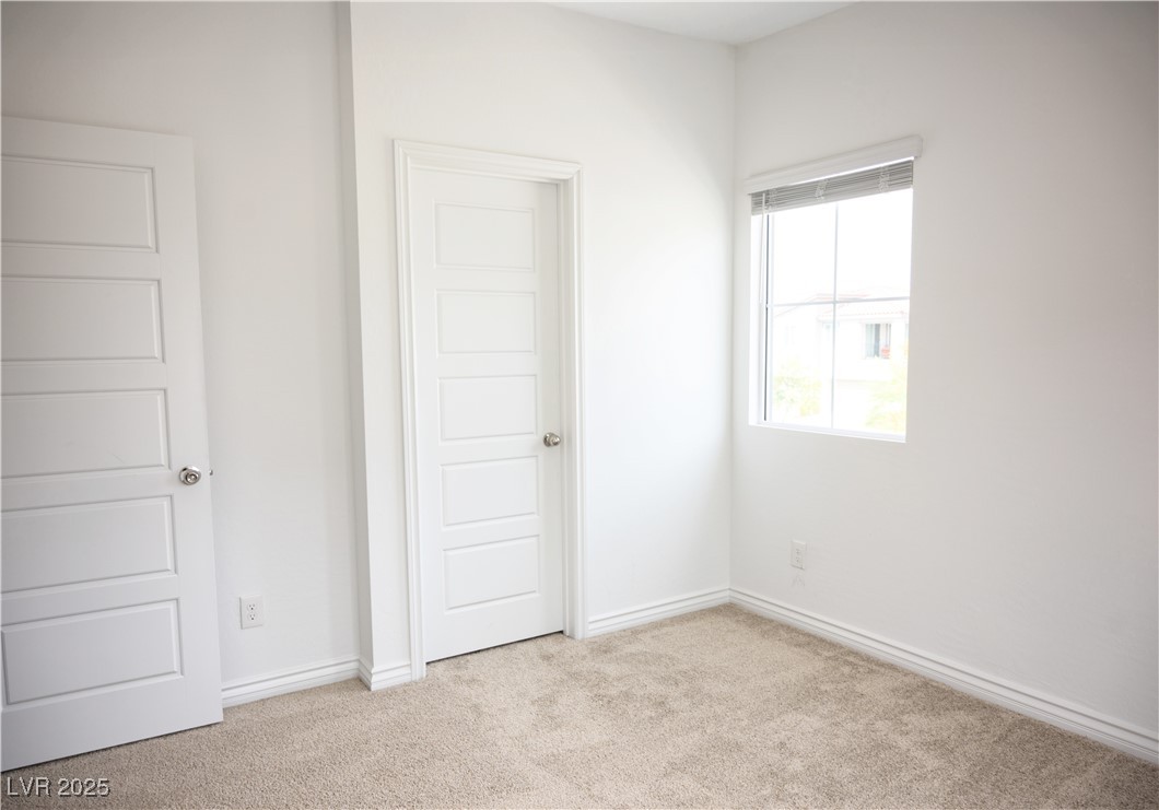 7342 North Decatur Boulevard, Unit 5 North Las Vegas, NV 89084 - Photo 21 of 29 Unfurnished bedroom featuring carpet flooring and baseboards