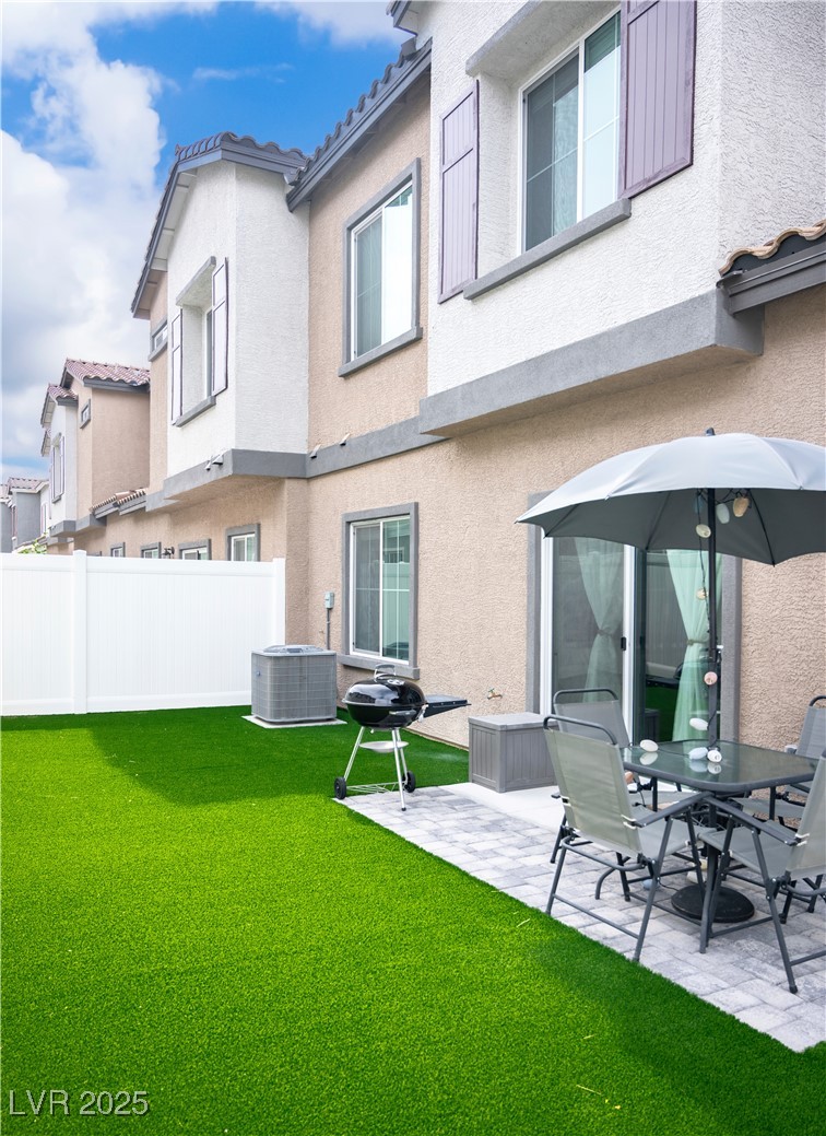 7342 North Decatur Boulevard, Unit 5 North Las Vegas, NV 89084 - Photo 24 of 29 Back of house with stucco siding, a patio, a tiled roof, and cooling unit