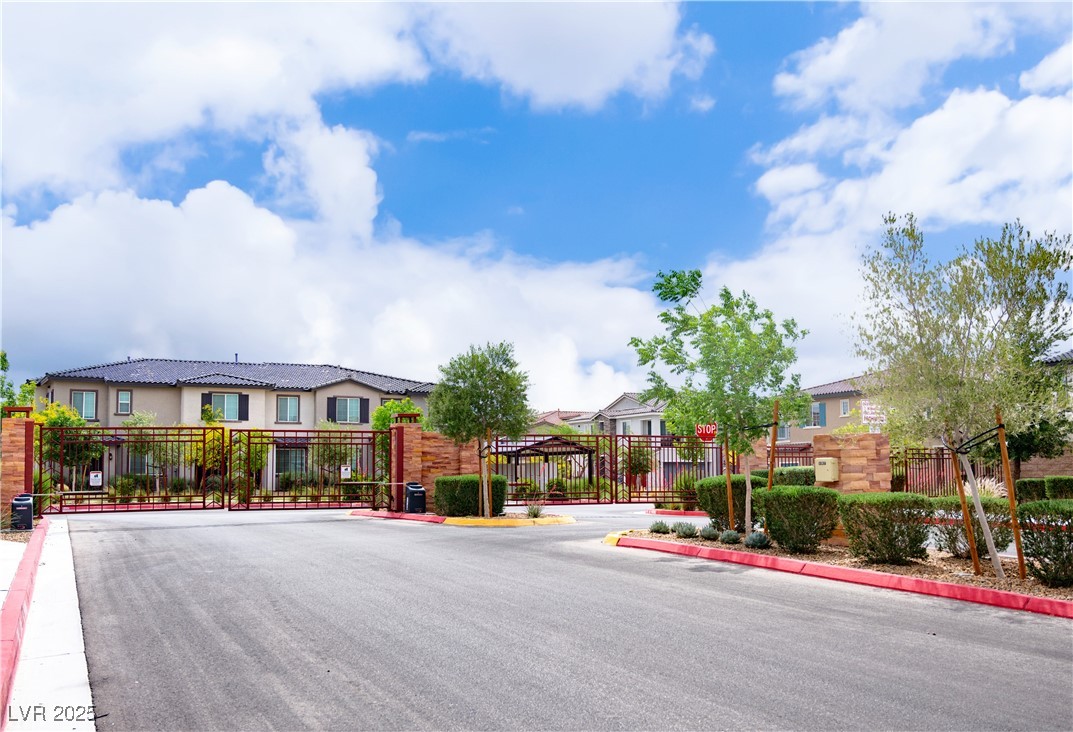7342 North Decatur Boulevard, Unit 5 North Las Vegas, NV 89084 - Photo 28 of 29 View of asphalt street featuring a gate, a gated entry, a residential view, and curbs