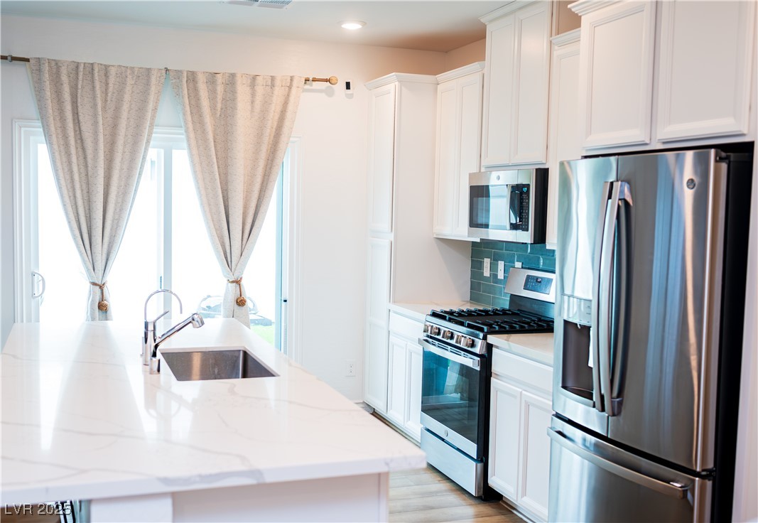 7342 North Decatur Boulevard, Unit 5 North Las Vegas, NV 89084 - Photo 6 of 29 Kitchen featuring stainless steel appliances, a sink, plenty of natural light, white cabinetry, and recessed lighting