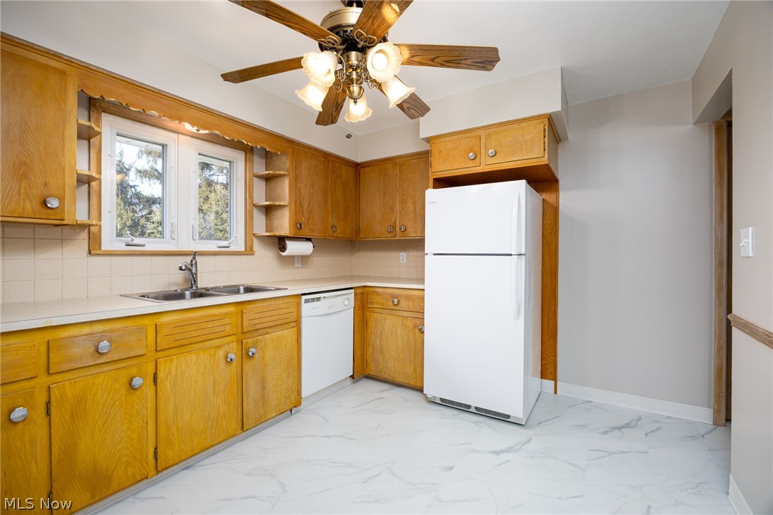 364 Mowbray Road Akron, OH 44333 - Photo 12 of 44 Kitchen featuring white appliances, light countertops, light marble finish floors, and backsplash