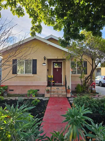 a front view of a house with a yard and potted plants