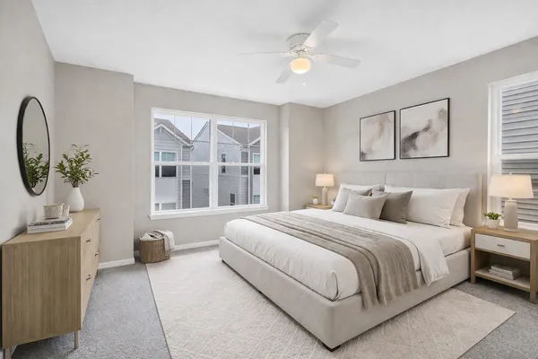 a bedroom with a bed a mirror and a large window