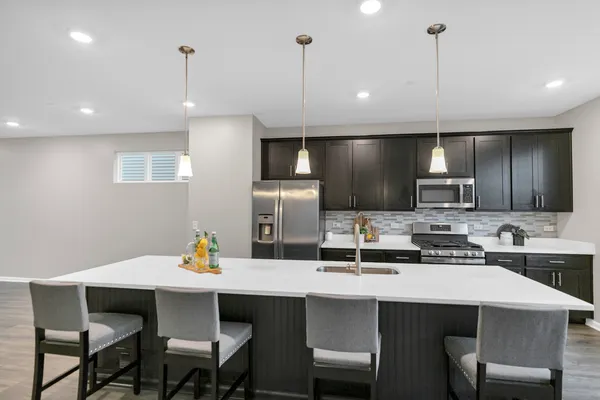 a kitchen with a table chairs refrigerator and microwave