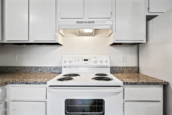 a white stove top oven sitting inside of a kitchen