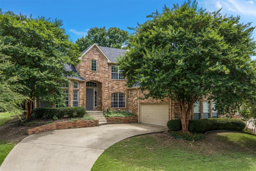 5607 Ranger Drive Rockwall, TX 75032 - Photo 5 of 40 Stone and brick facade residence featuring a two-story design, arched entry, multiple window styles, an integrated garage, and a curved concrete driveway