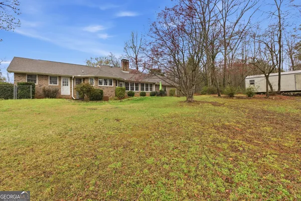 a view of a house next to a big yard with large trees