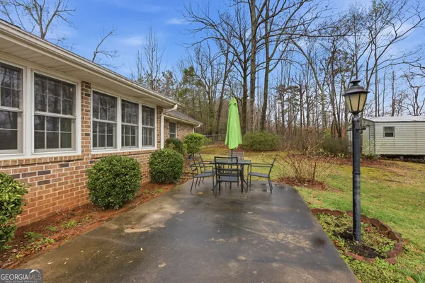 a view of a house with backyard and sitting area