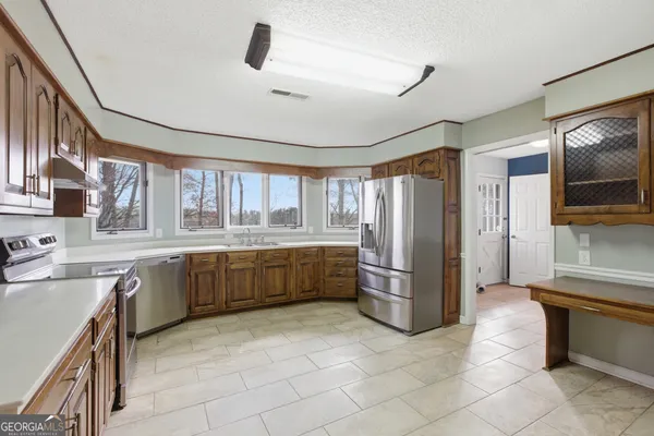 a large kitchen with a stove a refrigerator and a sink