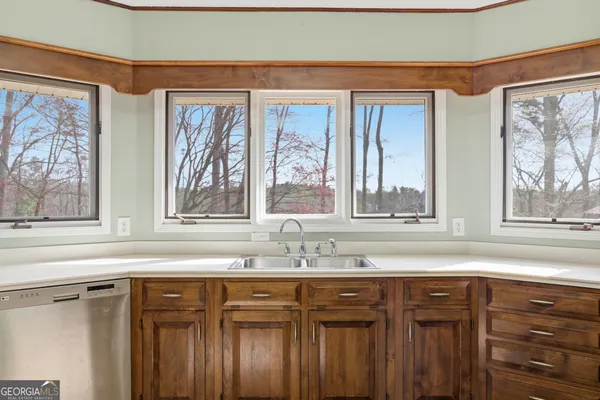 a large kitchen with stainless steel appliances granite countertop a stove top oven a sink dishwasher and cabinets with wooden floor