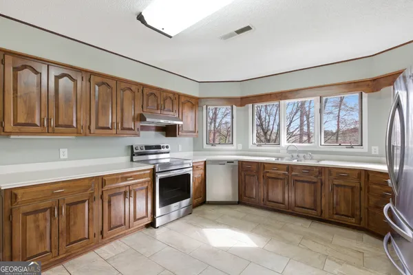 a kitchen with stainless steel appliances granite countertop a sink and a stove