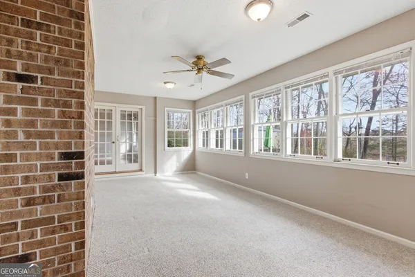 a view of an empty room with window and wooden floor