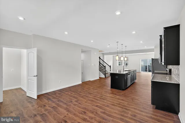 a view of kitchen with refrigerator microwave and wooden floor