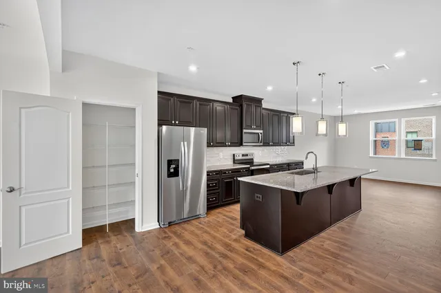 a large kitchen with stainless steel appliances granite countertop a stove and a refrigerator