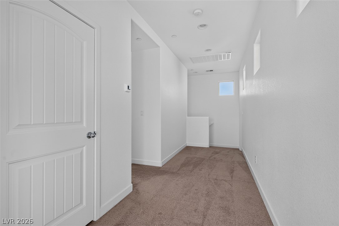 1100 East Sunset Road Henderson, NV 89011 - Photo 31 of 58 A well-lit landing area features soft carpeting and recessed lighting, offering a peaceful transition between levels.