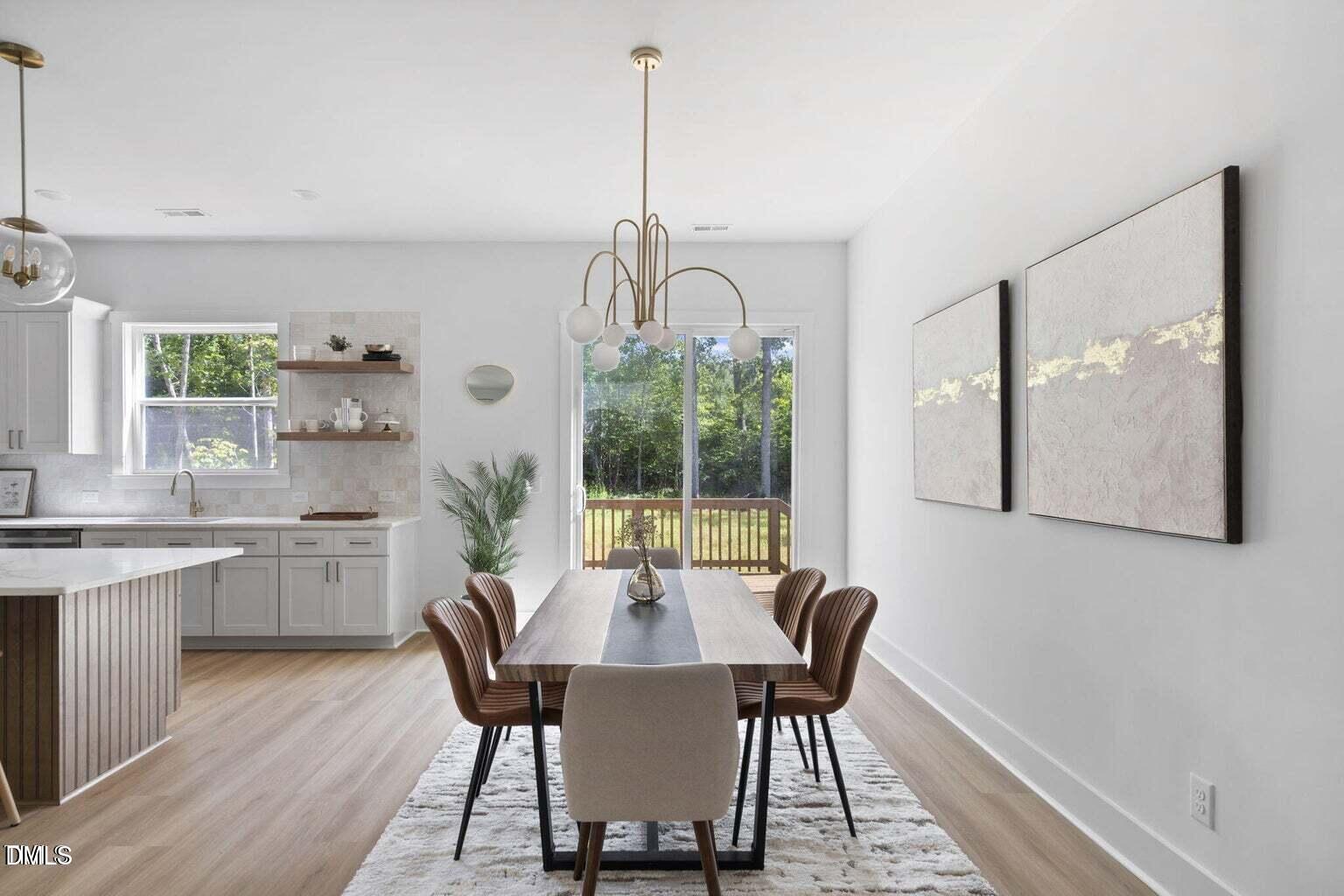 712 Oaks Lane Road Timberlake, NC 27583 - Photo 15 of 49 a dining room with wooden floor a chandelier a wooden table and chairs