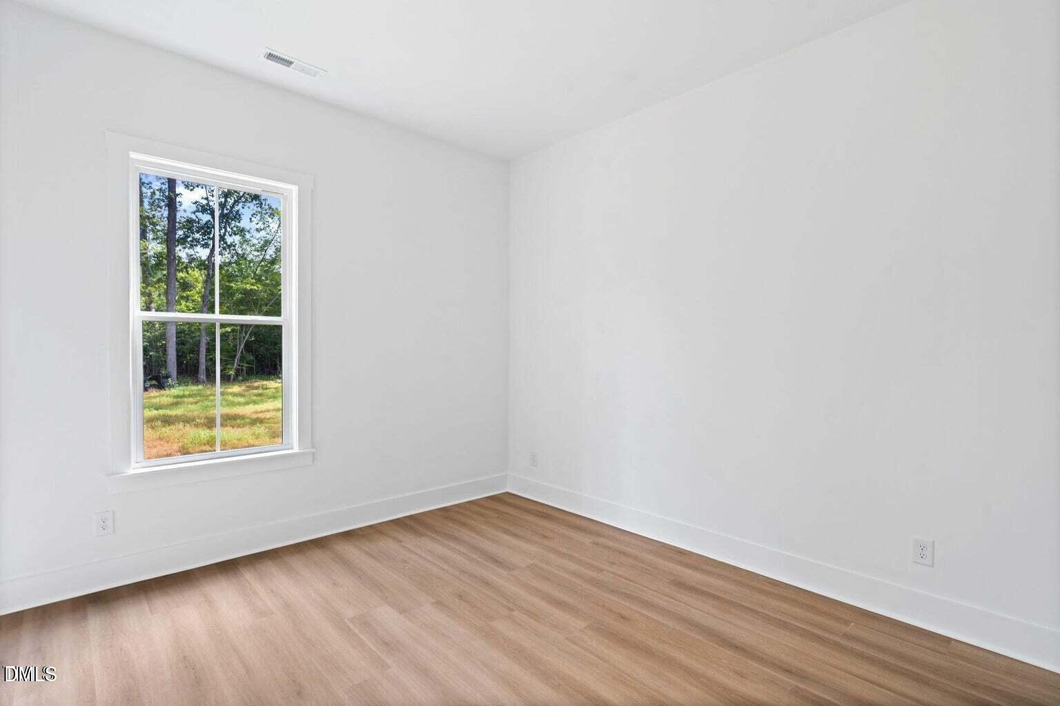712 Oaks Lane Road Timberlake, NC 27583 - Photo 16 of 49 an empty room with wooden floor and a window