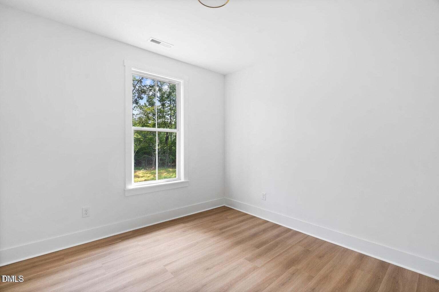 712 Oaks Lane Road Timberlake, NC 27583 - Photo 30 of 49 an empty room with wooden floor and window