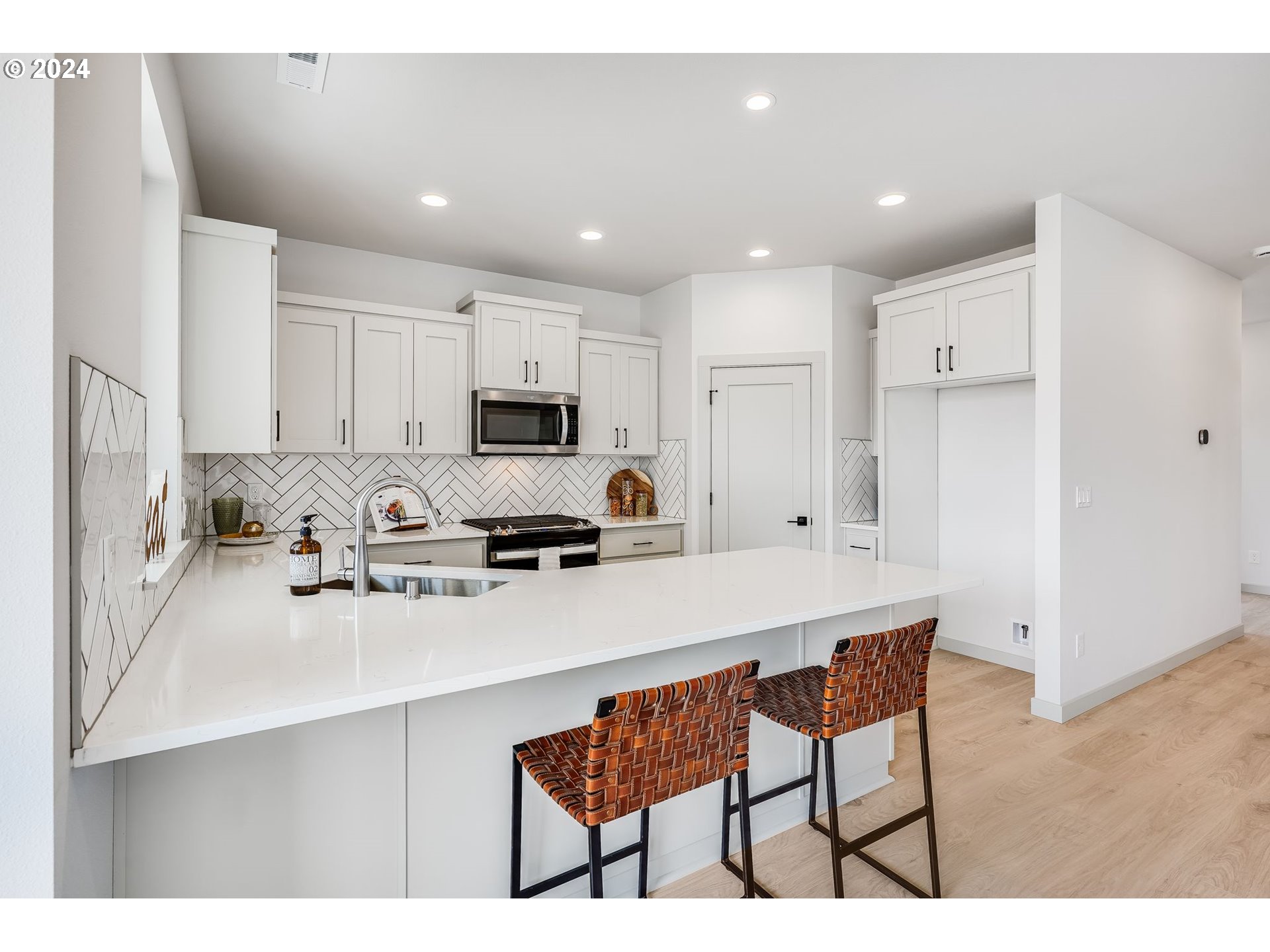 715 Northwest 174th Street Ridgefield, WA 98642 - Photo 6 of 20 a kitchen with stainless steel appliances a sink a stove a refrigerator cabinets and a dining table