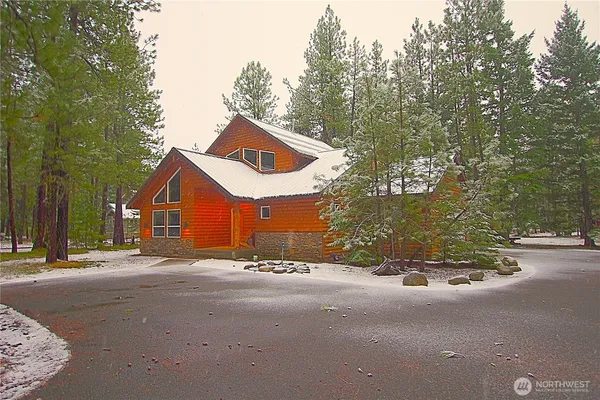 a view of a house with a yard and large trees