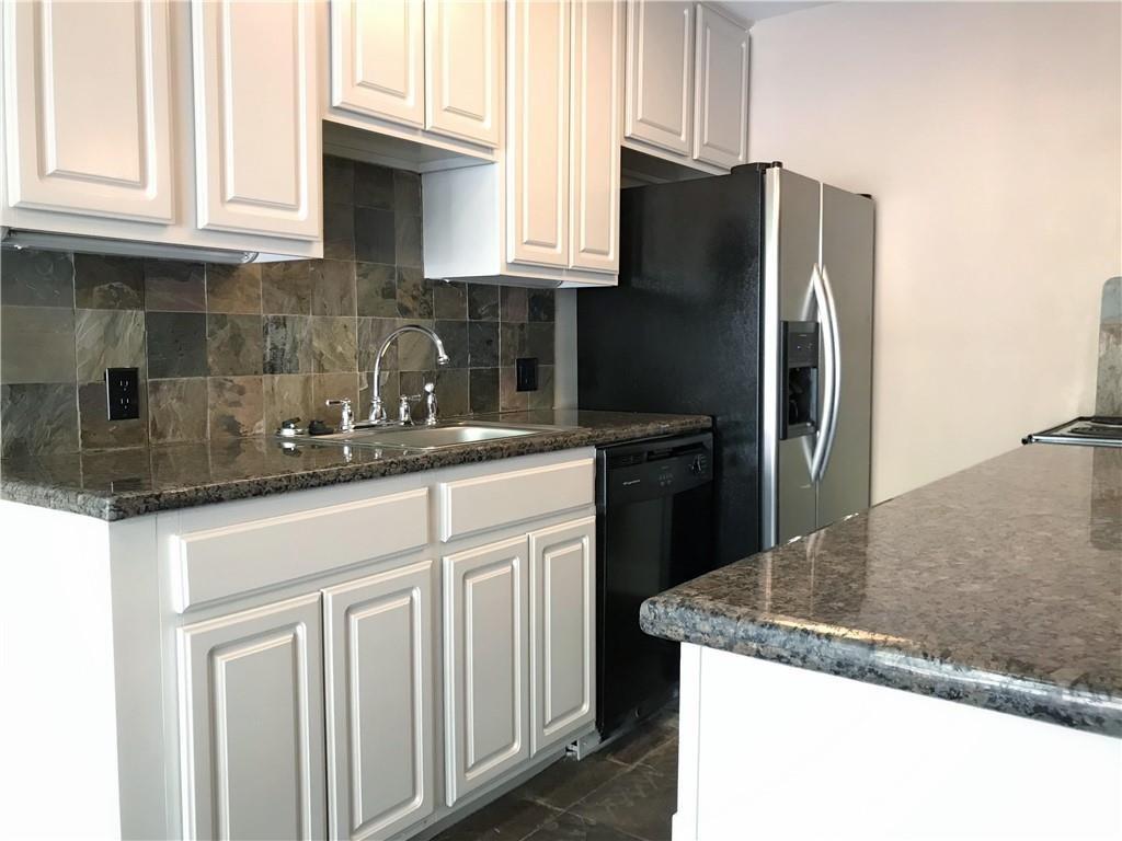 500 East Riverside Drive, Unit 154 Austin, TX 78704 - Photo 6 of 14 Kitchen featuring white cabinetry, granite-finish countertops, a stainless steel side-by-side refrigerator, a black dishwasher, and a stone tile backsplash