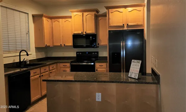 a kitchen with stainless steel appliances granite countertop a sink a stove and a refrigerator