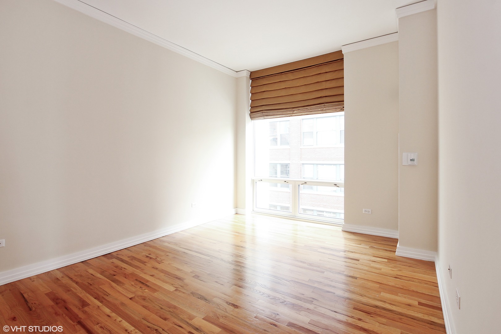 170 West Polk Street, Unit 904 Chicago, IL 60605 - Photo 7 of 10 a view of an empty room with wooden floor and a window