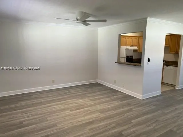 a view of empty room with wooden floor