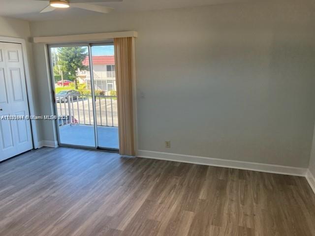 594 Saxony M, Unit 594 Delray Beach, FL 33446 - Photo 6 of 9 an empty room with wooden floor and windows