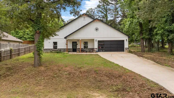 a view of a house with backyard and trees