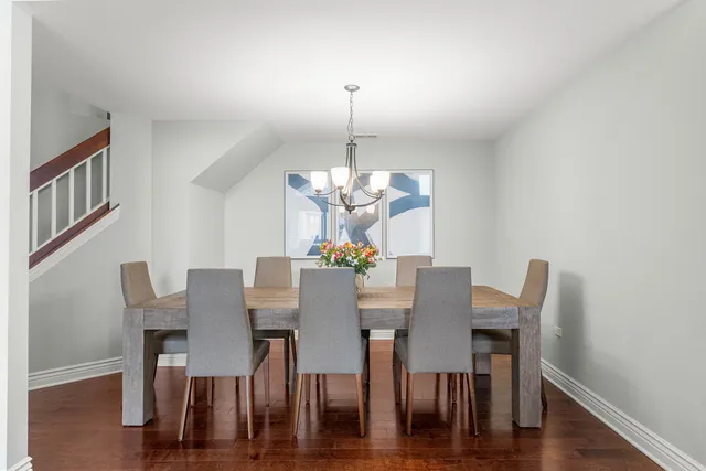 a view of a dining room with furniture a chandelier and wooden floor