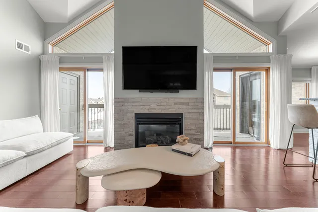 a living room with furniture a flat screen tv a fireplace and a table