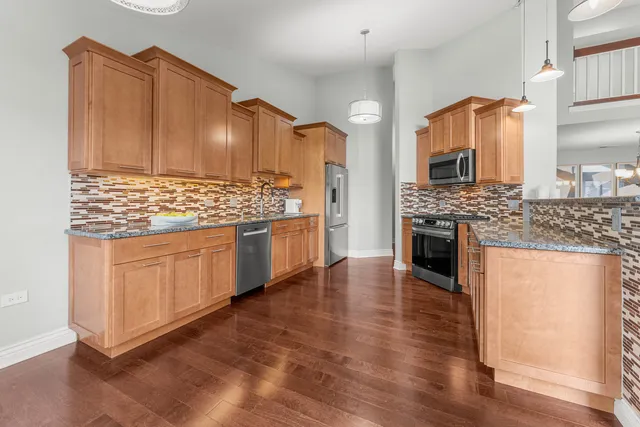 a kitchen with kitchen island granite countertop wooden cabinets and a stove