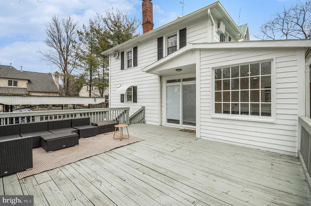 a roof deck with a table and chairs and wooden floor