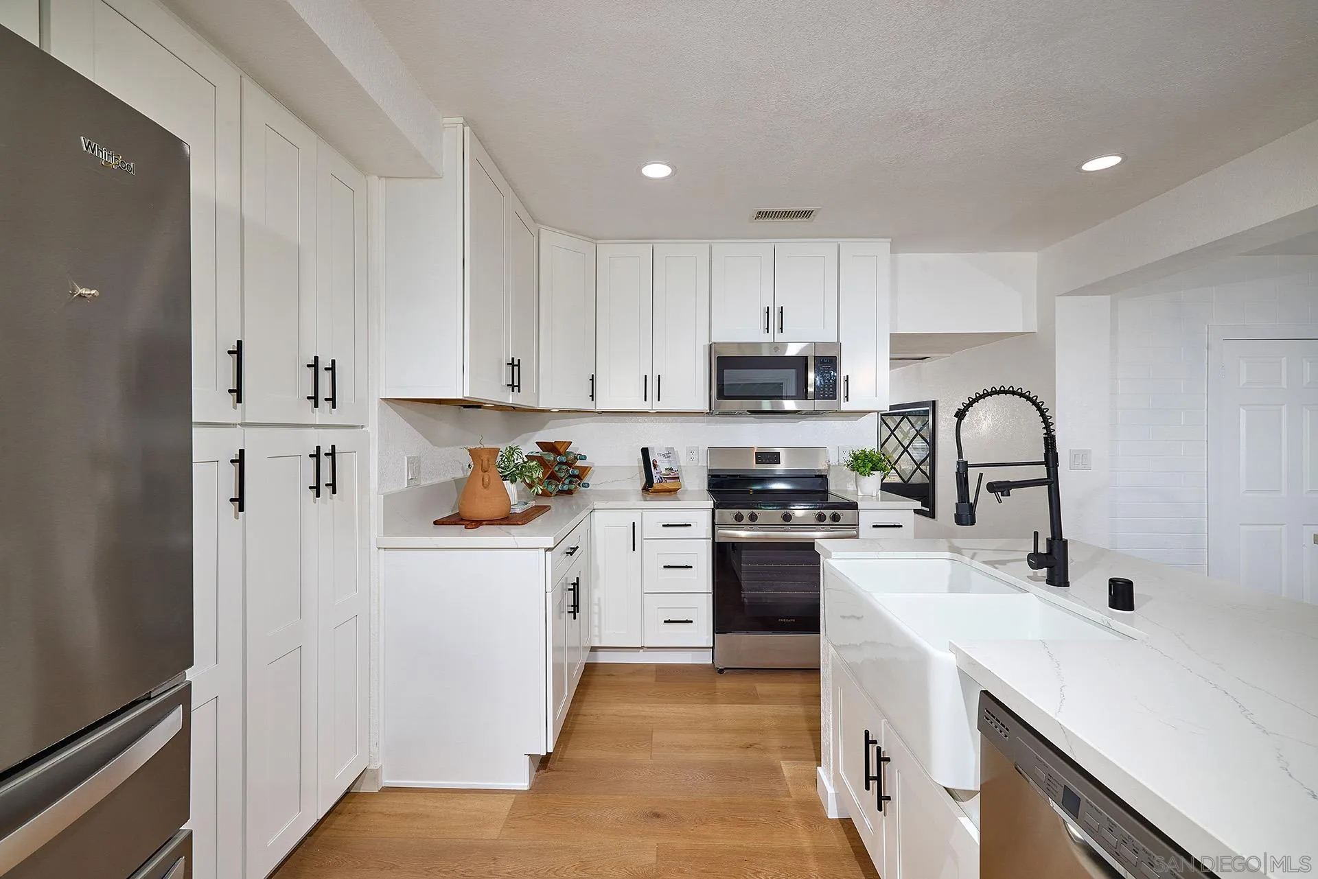6185 Alpine Boulevard Alpine, CA 91901 - Photo 5 of 39 a kitchen with white cabinets and appliances
