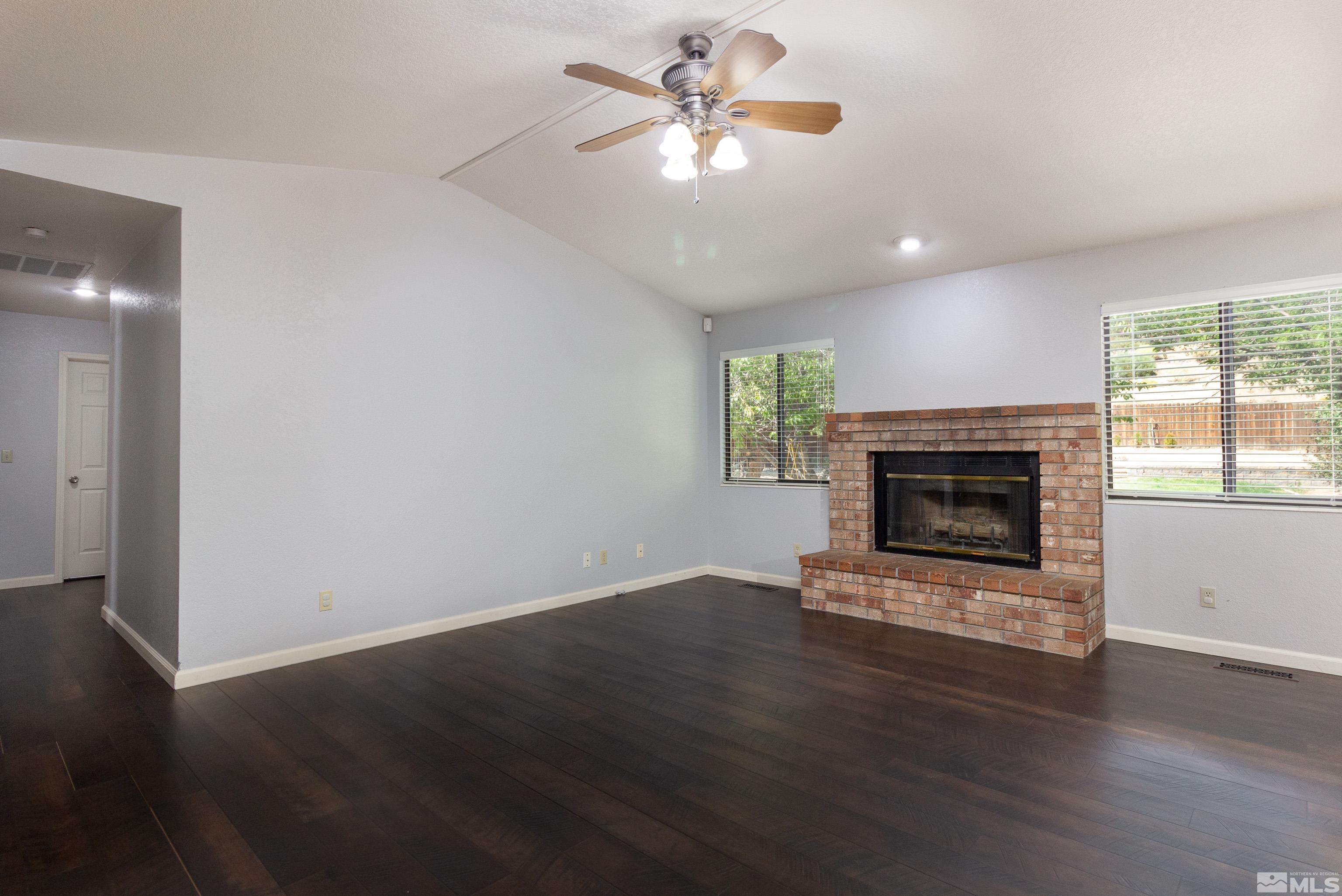 5331 Coit Drive Reno, NV 89523 - Photo 18 of 28 an empty room with wooden floor a fireplace and a window