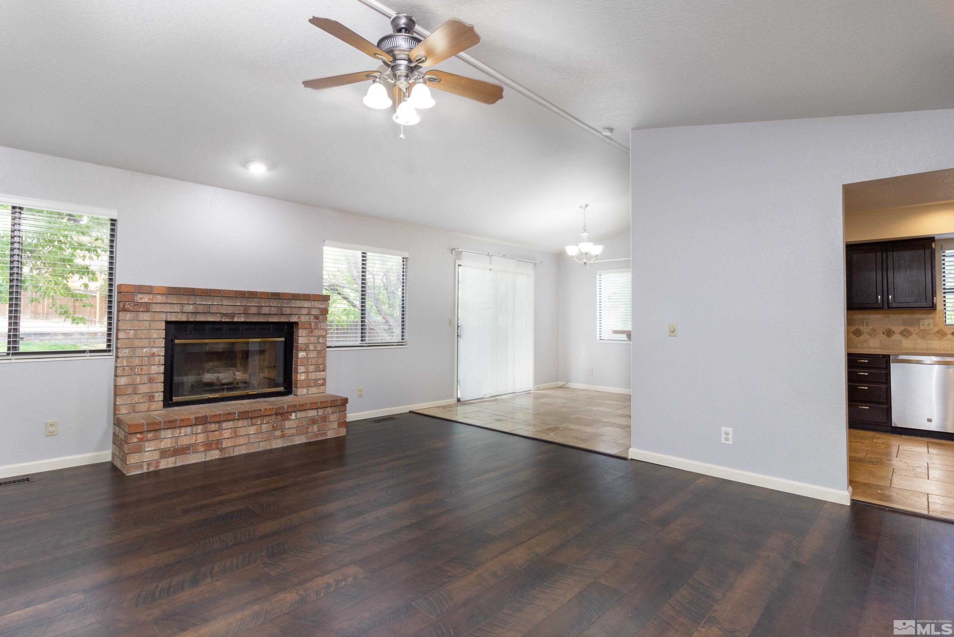 5331 Coit Drive Reno, NV 89523 - Photo 20 of 28 an empty room with wooden floor a ceiling fan a fireplace and windows