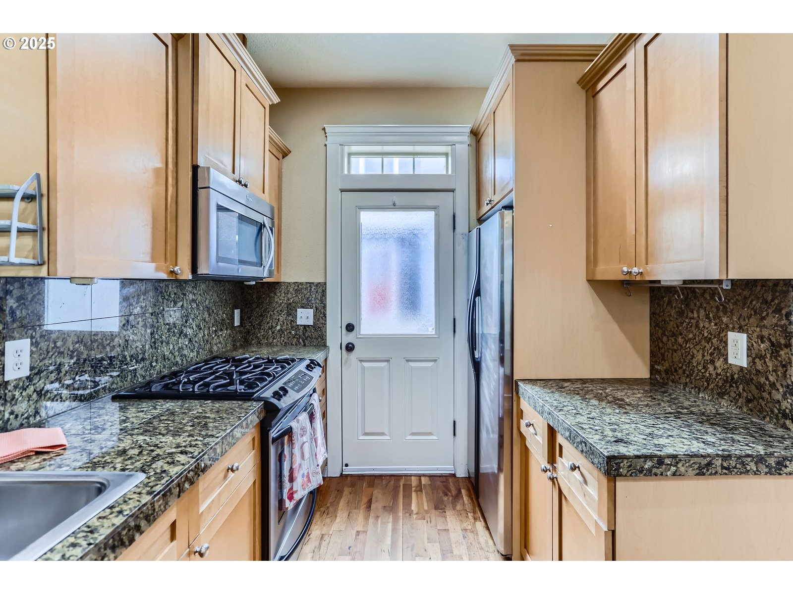 343 Northeast Bryant Street Portland, OR 97211 - Photo 11 of 26 a kitchen with kitchen island granite countertop a refrigerator stove and sink