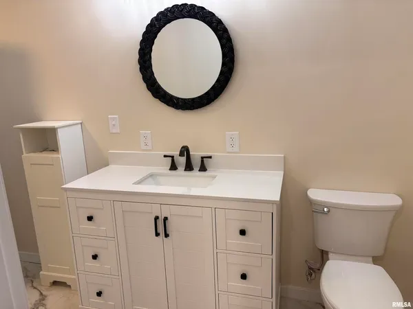 a bathroom with a toilet a sink and a mirror
