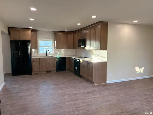 a large kitchen with stainless steel appliances granite countertop a stove a sink and a refrigerator